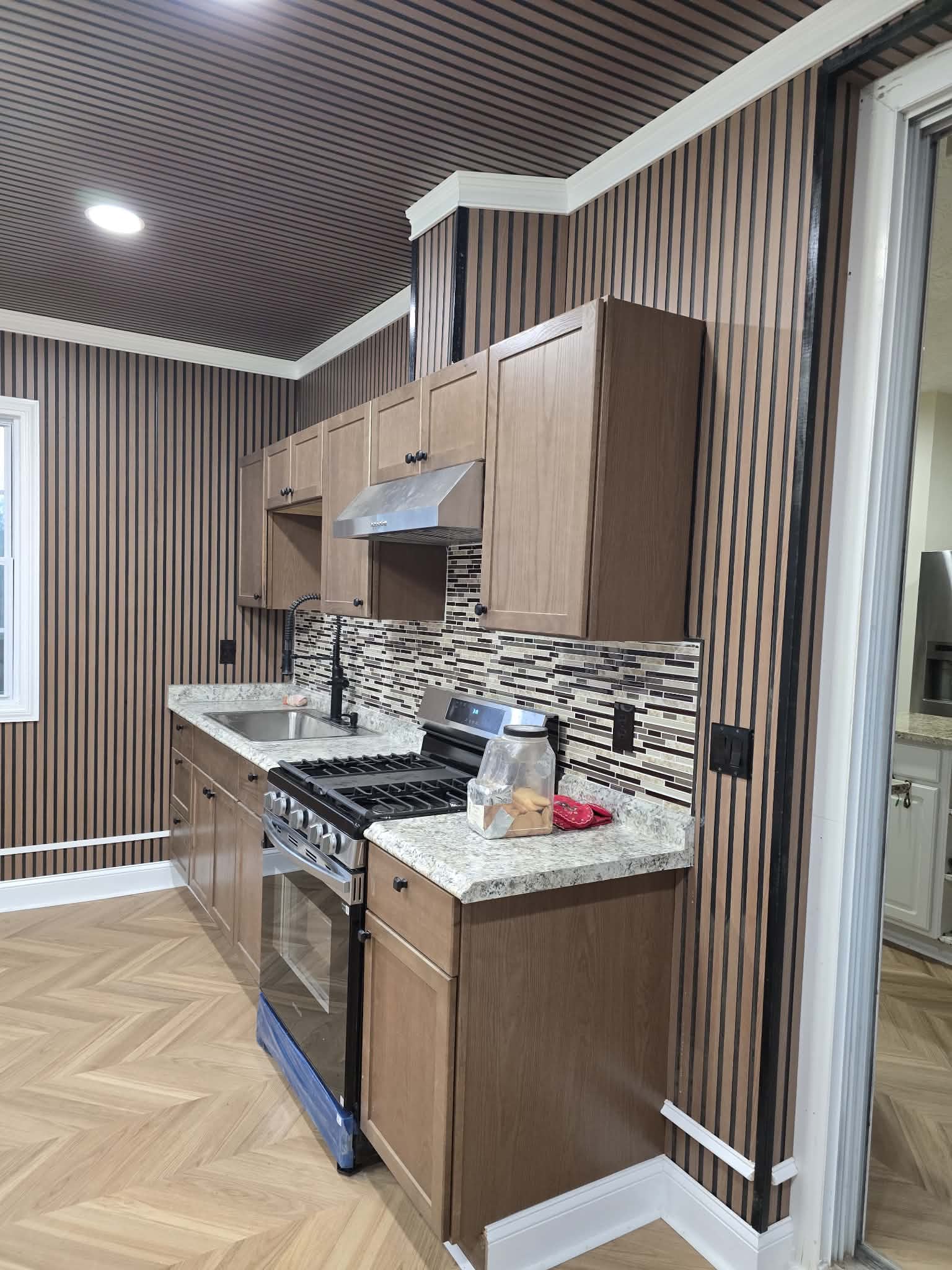 Finished kitchen remodel with custom cabinetry and herringbone floor